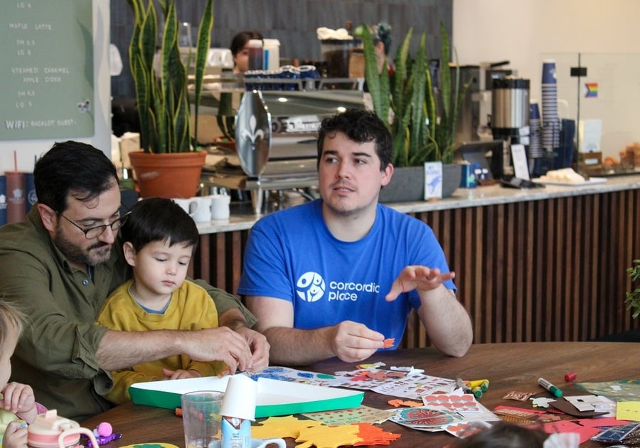 two men with a little kid at a cafe