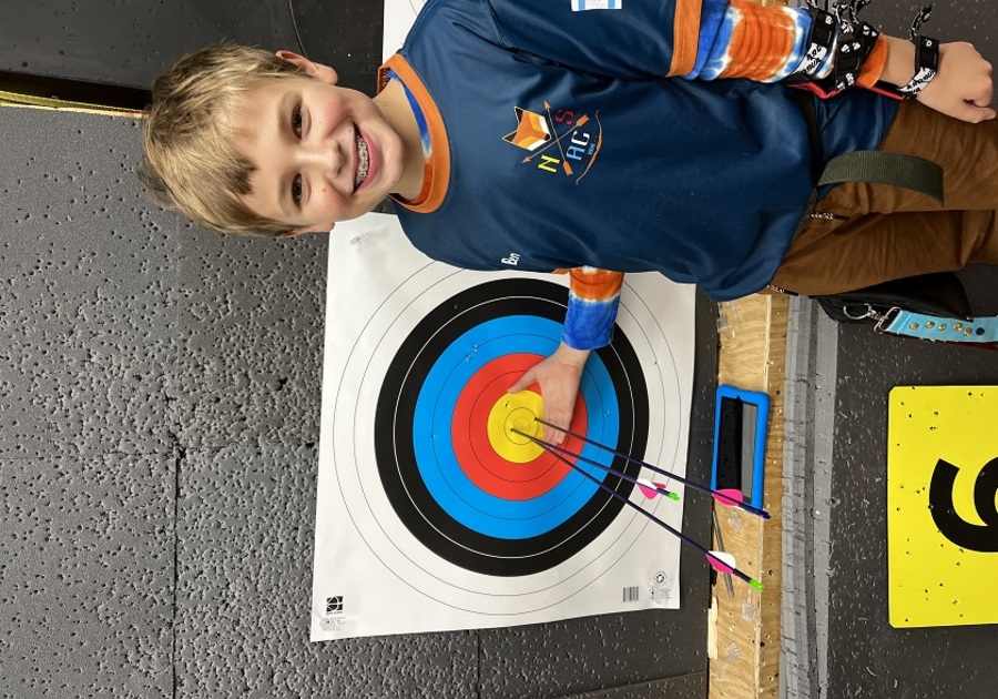 kid with three arrows in the center of the bullseye