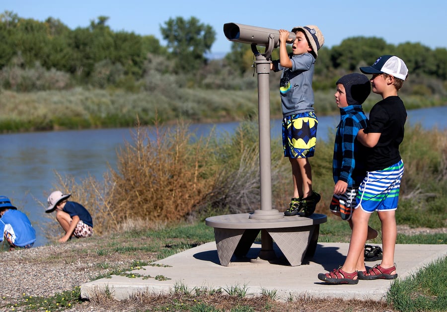 children looking through a telescope near the shore at James M Robb Colorado River State Park