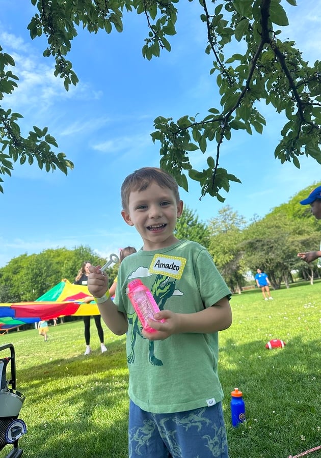 boy blowing bubbles outside