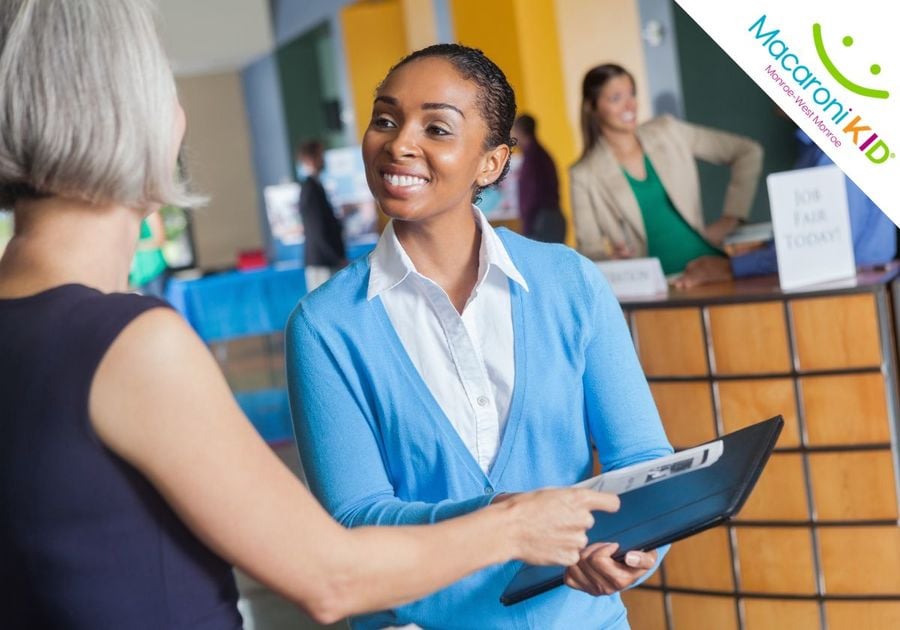 A teen handing her resume to a potential employer at an employment expo.