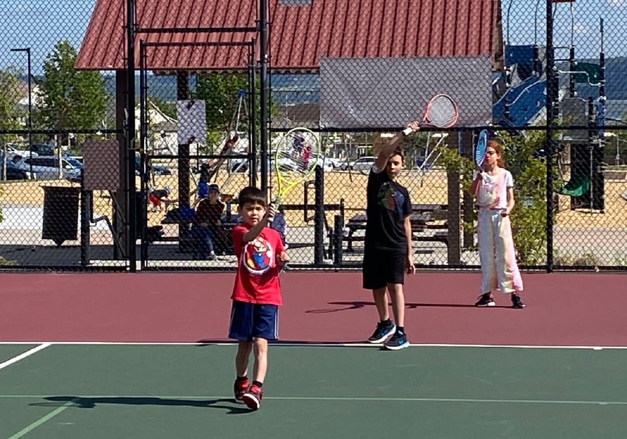 kids lining up to practice tennis serve at Castle Rock Tennis camp