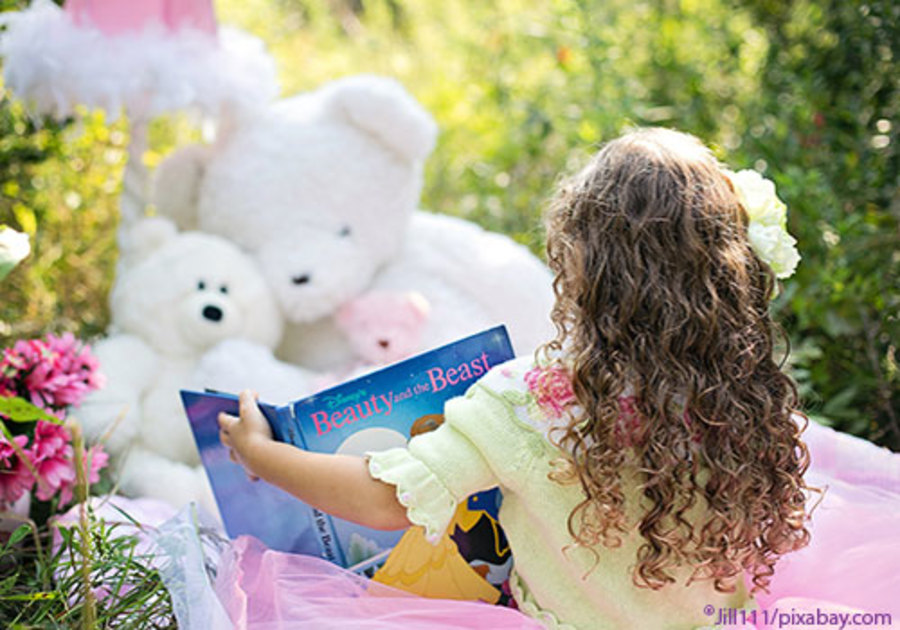 Little Girl reading to her bears