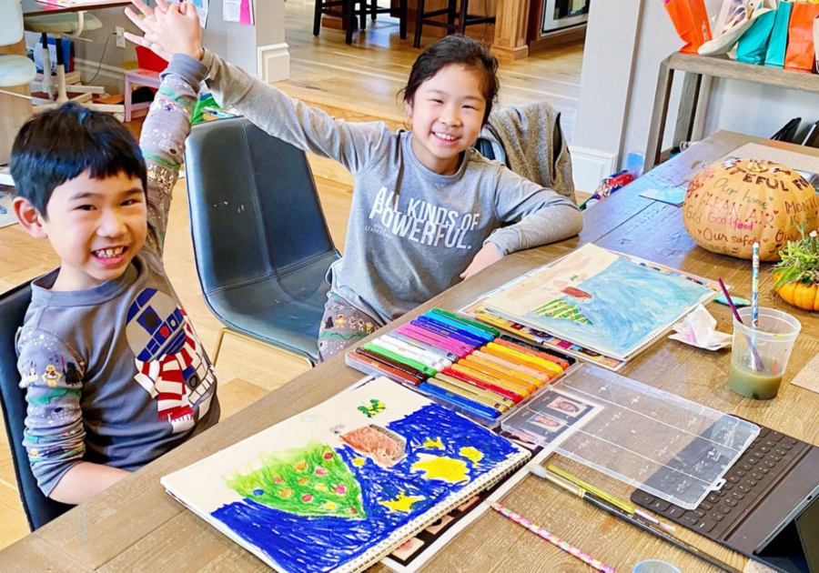 Two children giving high fives after completing art project