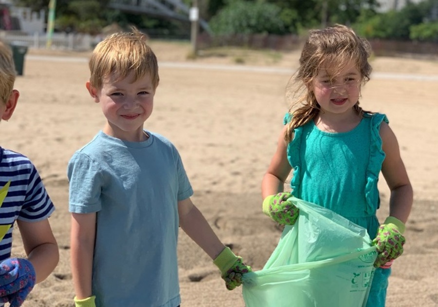 two grade school kids cleaning the beach