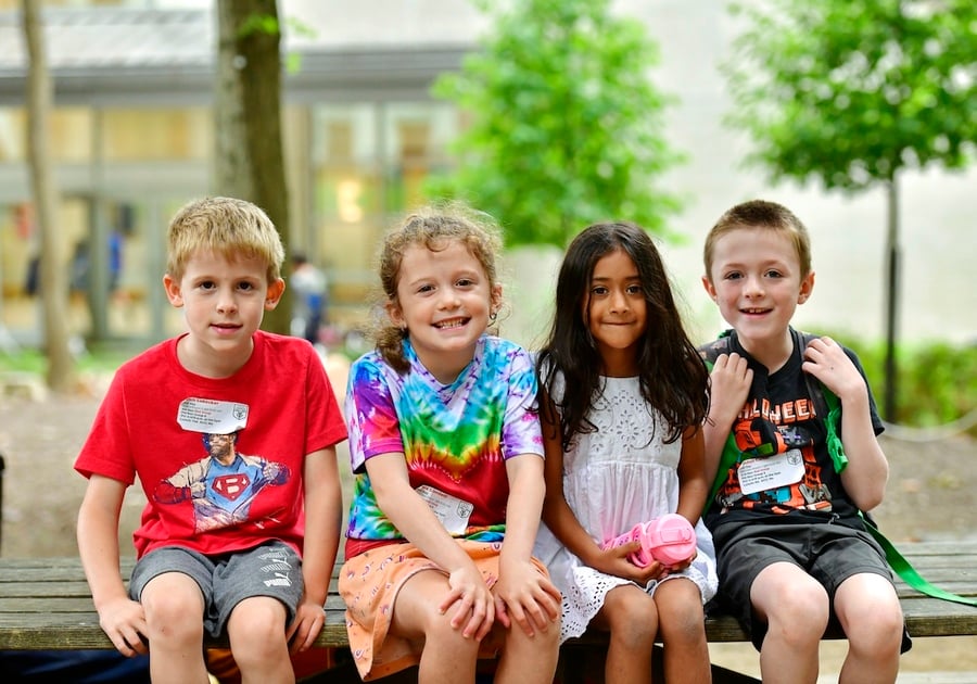 children sitting on a bench outside