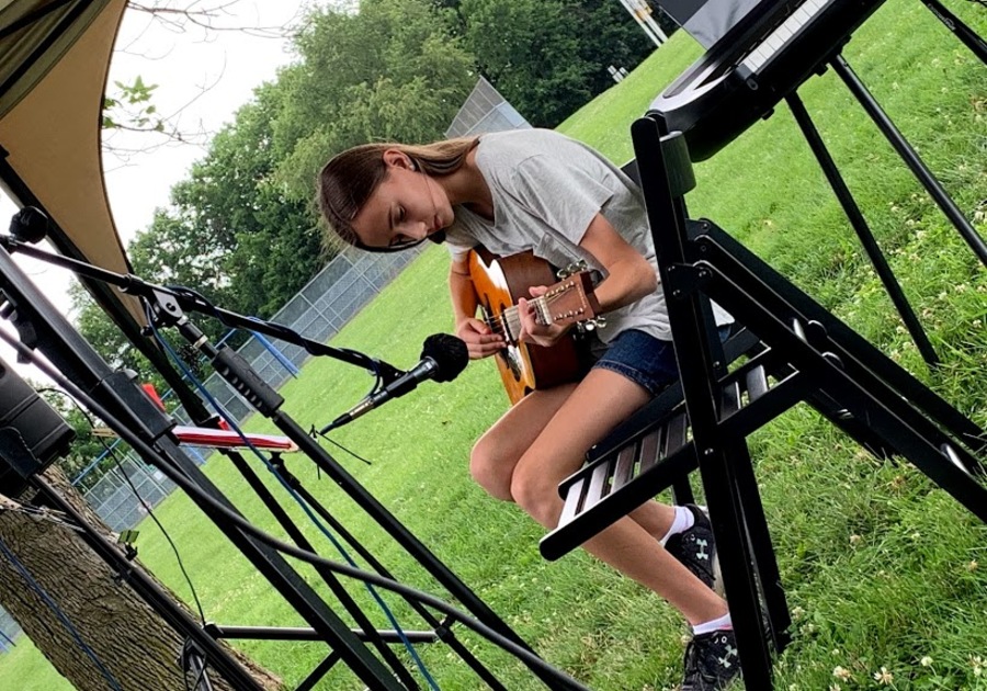 girl playing guitar outside