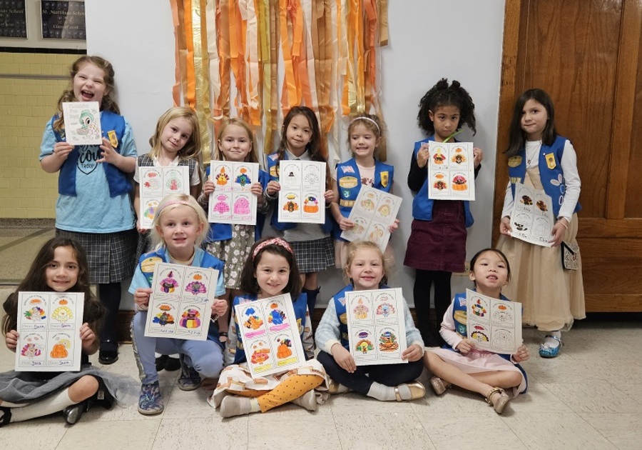 girl scout troop holding up their artwork