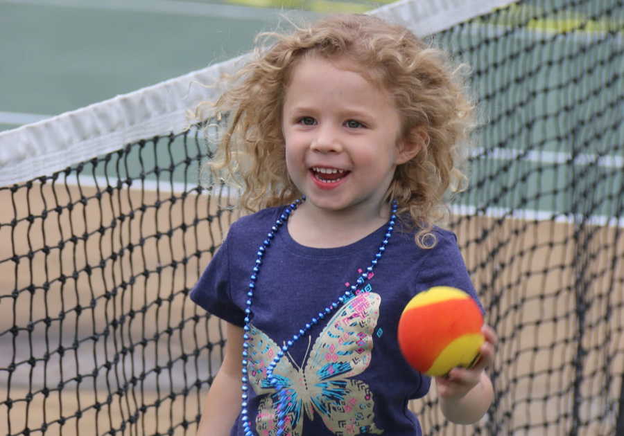 child; tennis; tennis ball; net; curly hair