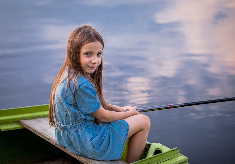Girl fishing from boat on lake