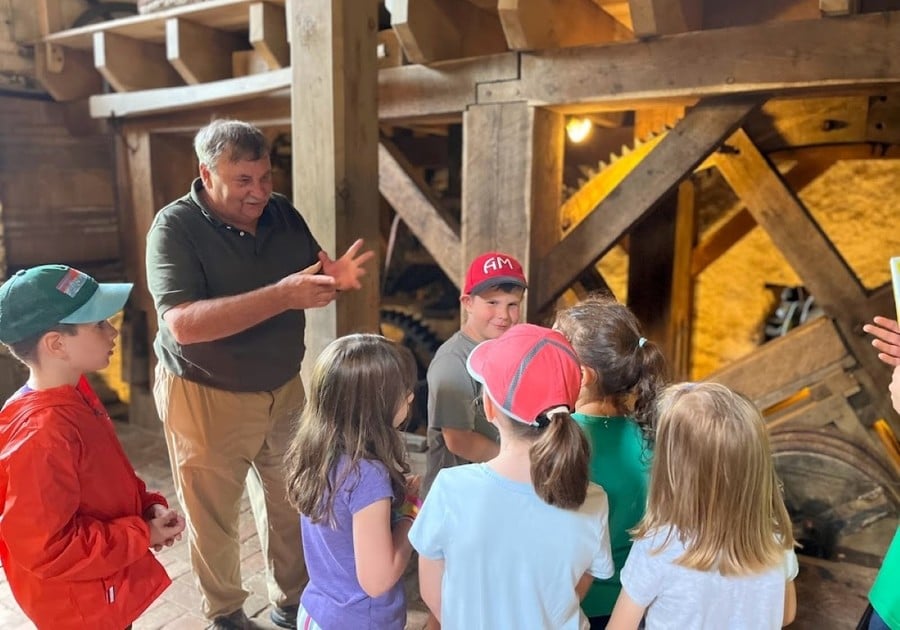 Man leading children on Mill tour at Newlin Grist Mill