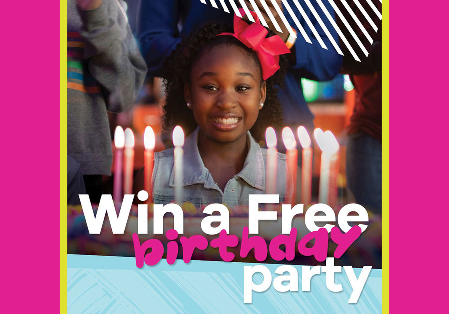 Girl having fun in front of birthday cake with lit candles