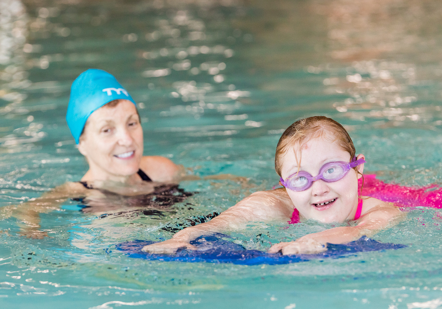 girl with down syndrome learning to swim with an instructor