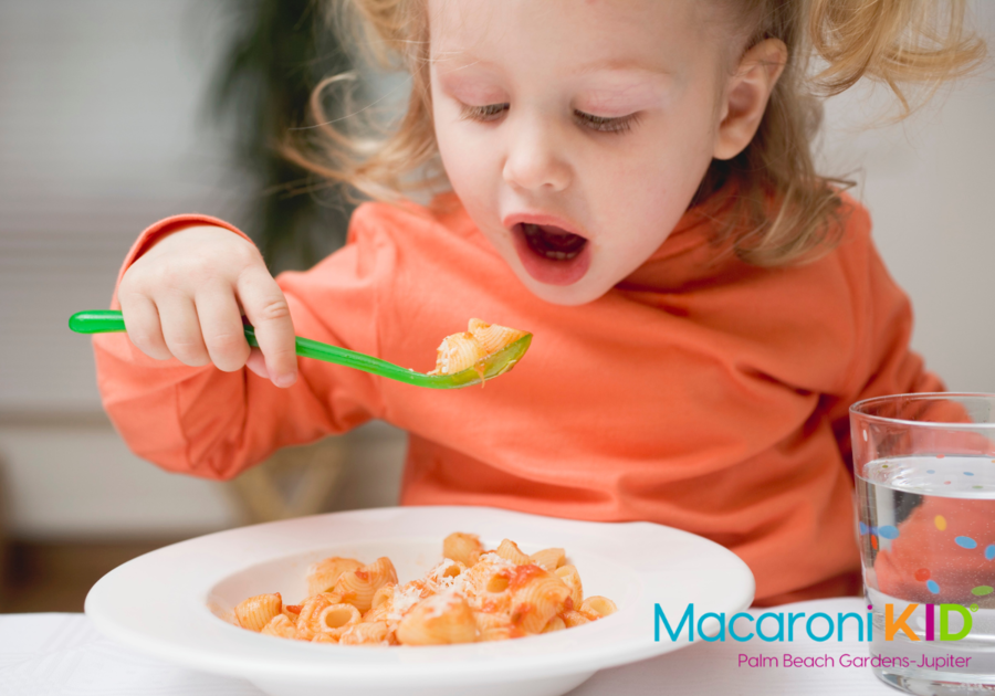 Toddler eating pasta