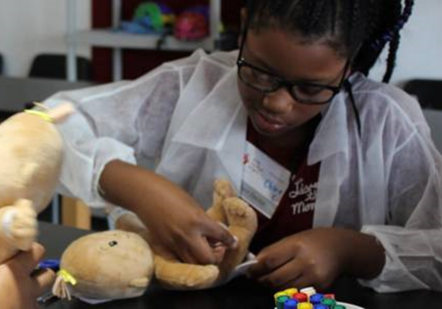 Child with a stuffed baby doll at Little Pediatrician School After-School Program at Little Medical School of the Treasure Coast