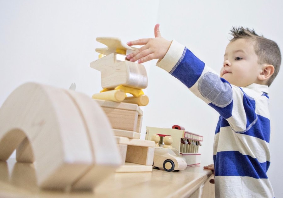 young child playing with wooden blocks
