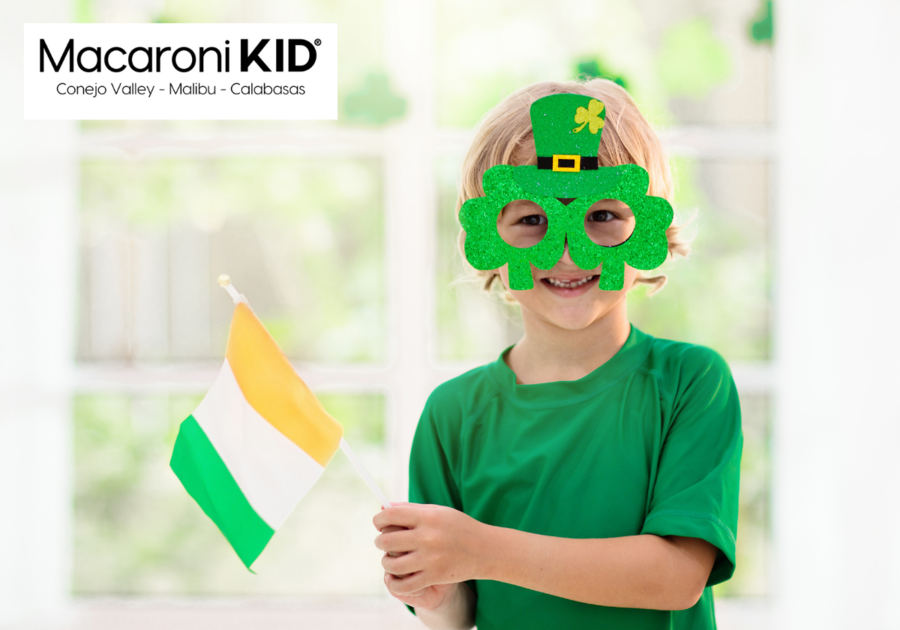 St. Patrick's Day, young boy wearing fun glasses with shamrocks and green top had holding an Irish flag