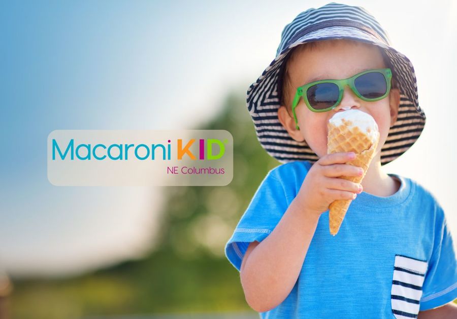 little boy in bucket hat and sunglasses eats an ice cream cone