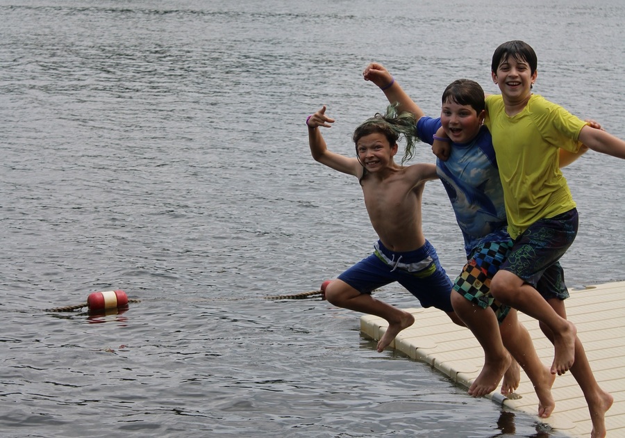 Children jumping off a raft into a lake