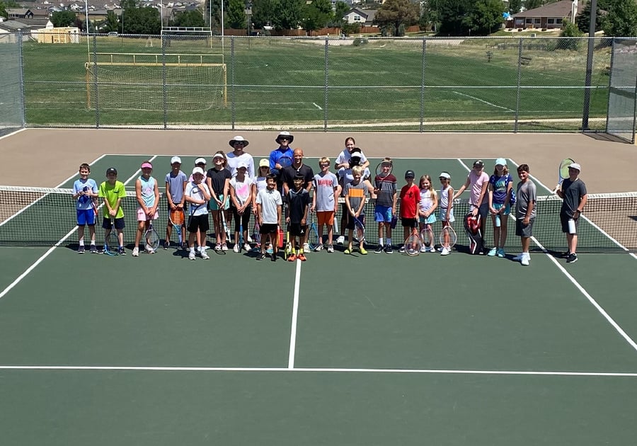 Group photo at the net at Castle Rock Tennis Summer Camp