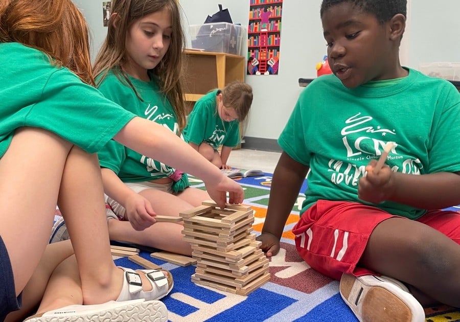 Three kids stacking keva planks