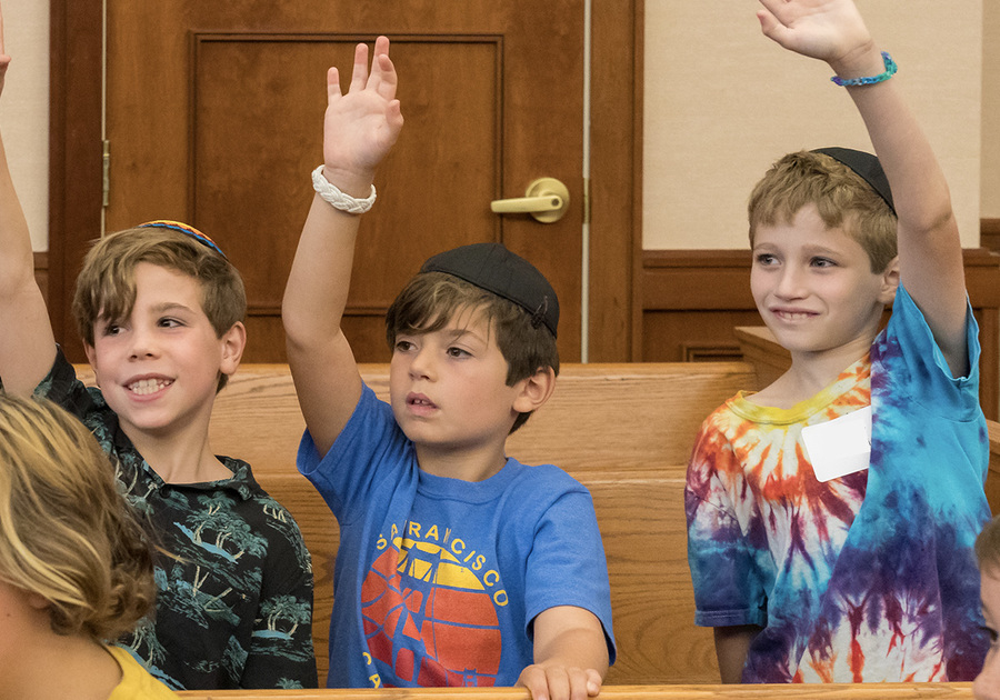 Three boys raising their hands