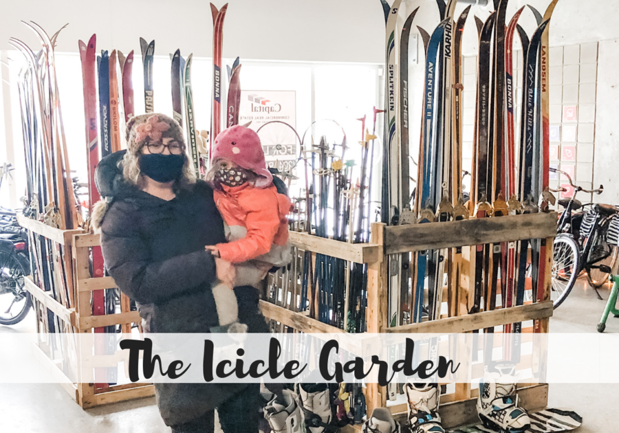 Mom and daughter standing in front of rakes of skis