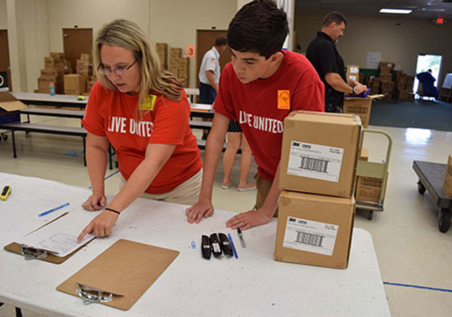 Volunteers Leslie Judd and Evan McCarthy sort supplies during last year’s Tools for Success program
