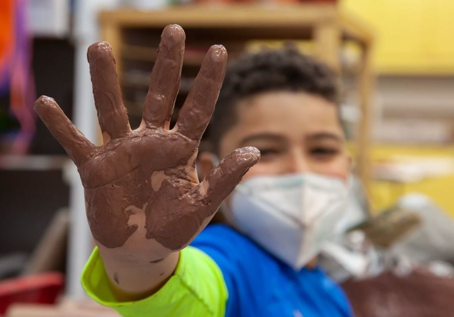 kids with hand covered in clay