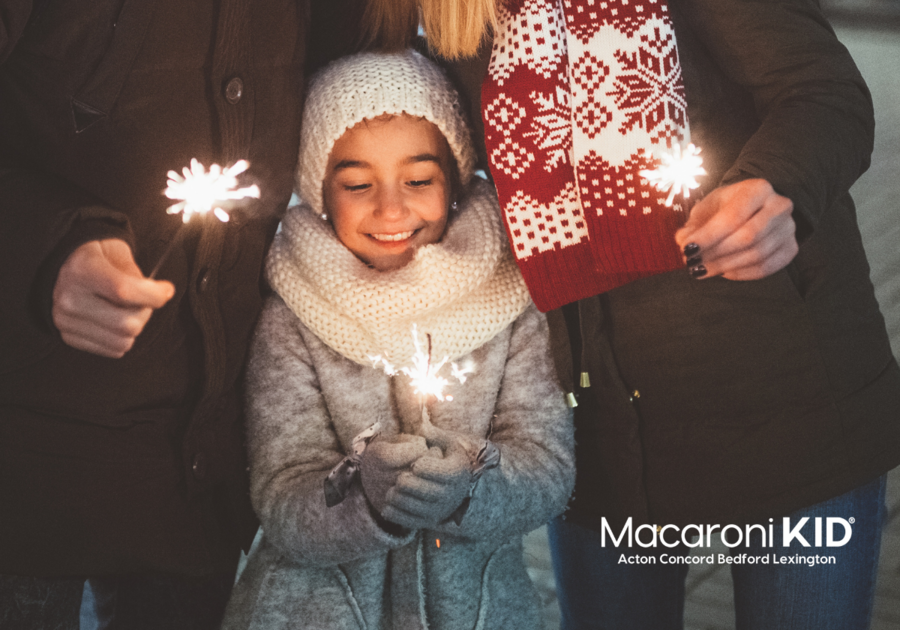 Family holding sparklers at night