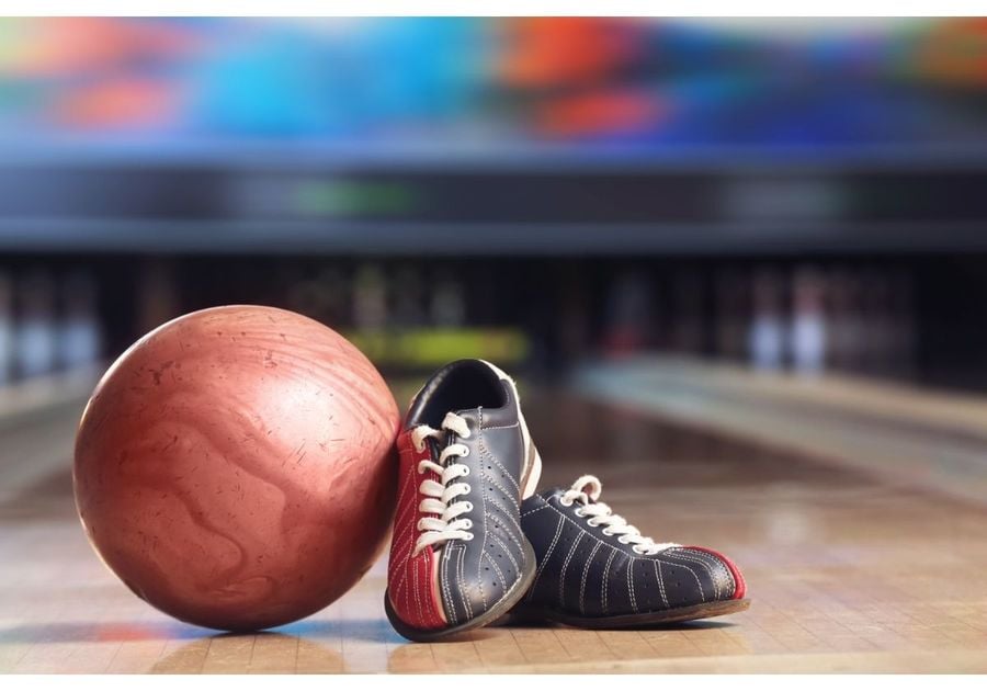 Bowling shoes and ball in focus with bowling lane and pins blurred in the background