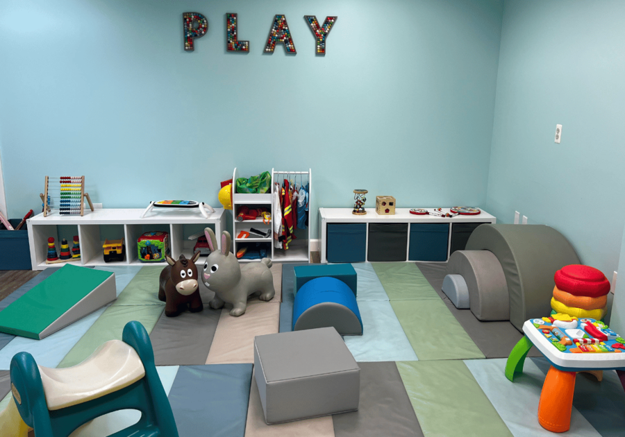 New Play room with soft mats, toys, blocks, cubbies. The word PLAY is on the wall.