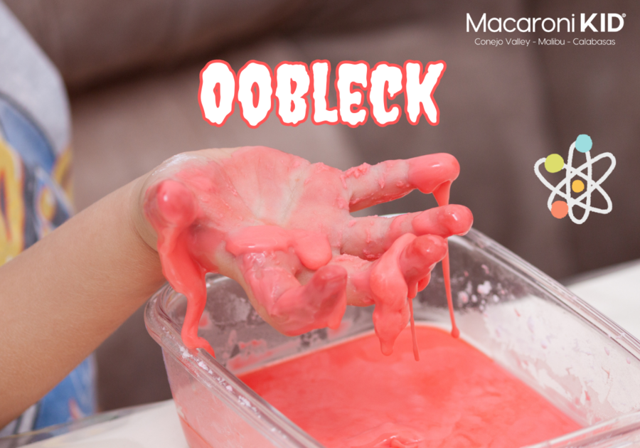 Childs hand with Pink Oobleck oozing into a bowl