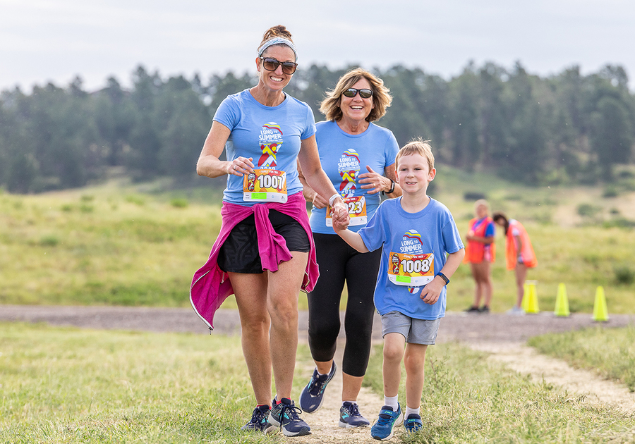 two adults and a child participating in So Long to Summer 5K