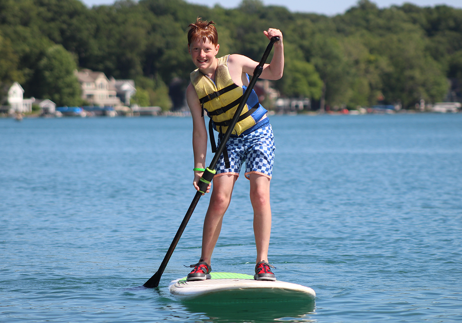 tween boy paddle boarding