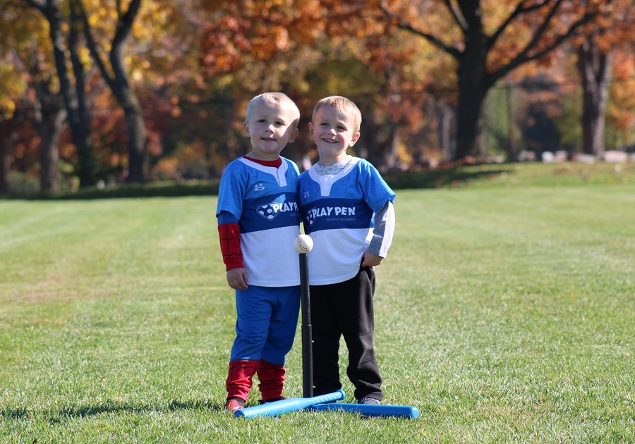 two twin boys posing on soccer field