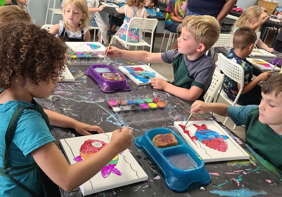 photo of campers painting a fish canvas