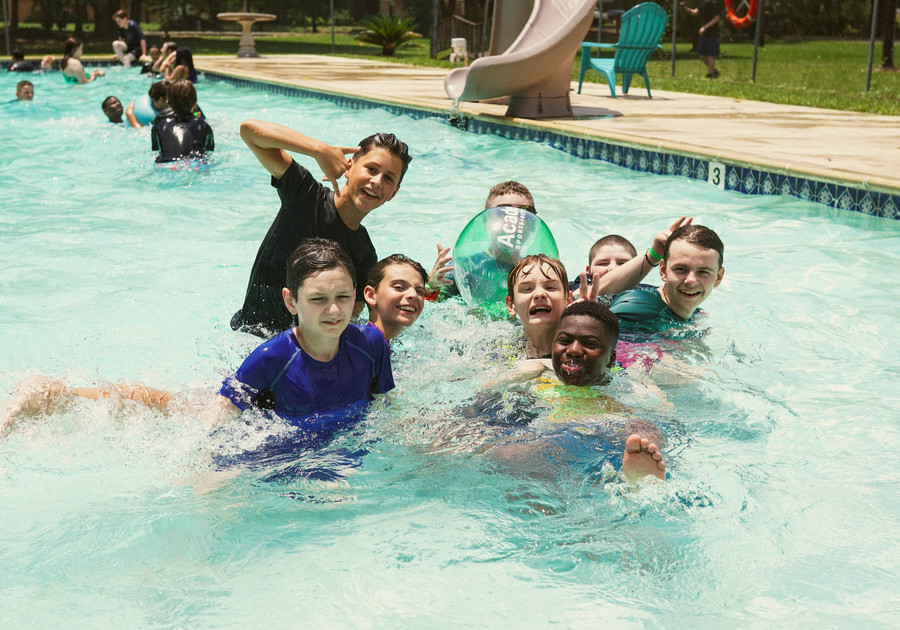 Young boy campers posing for a picture in a pool