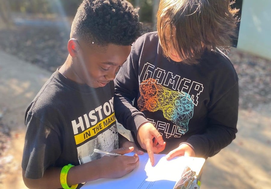 photo of 2 boys looking at clipboard