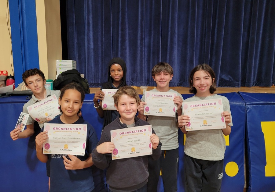 six grade school kids posing with certificates