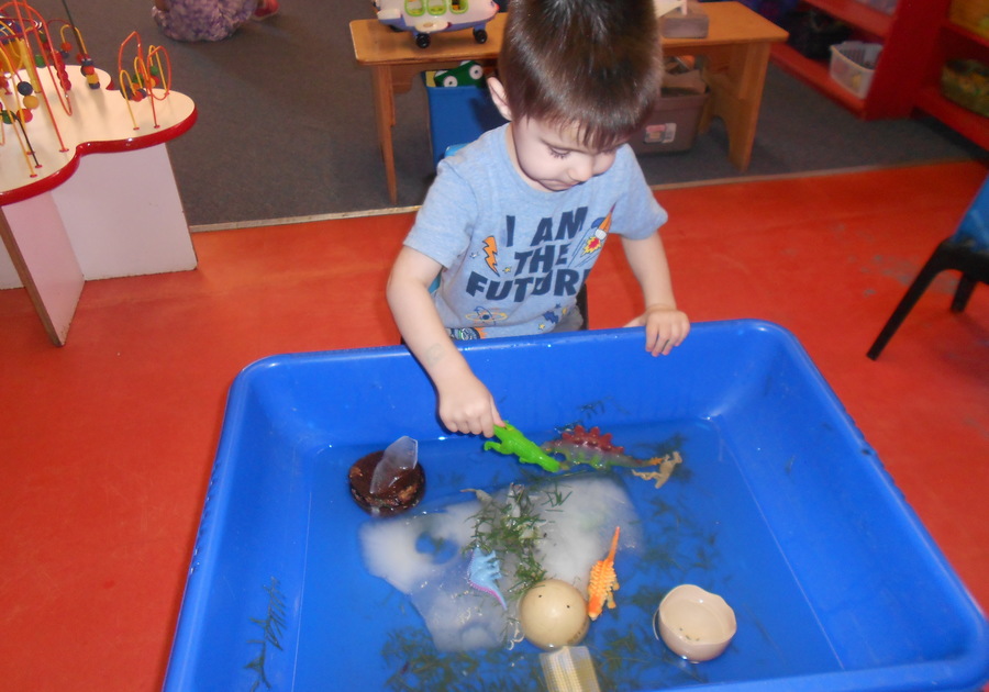Preschool child playing in water table at International School for Peace in Tucson