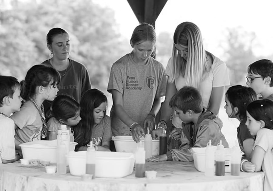 Camp Wonderkin campers and staff looking at nature at a table