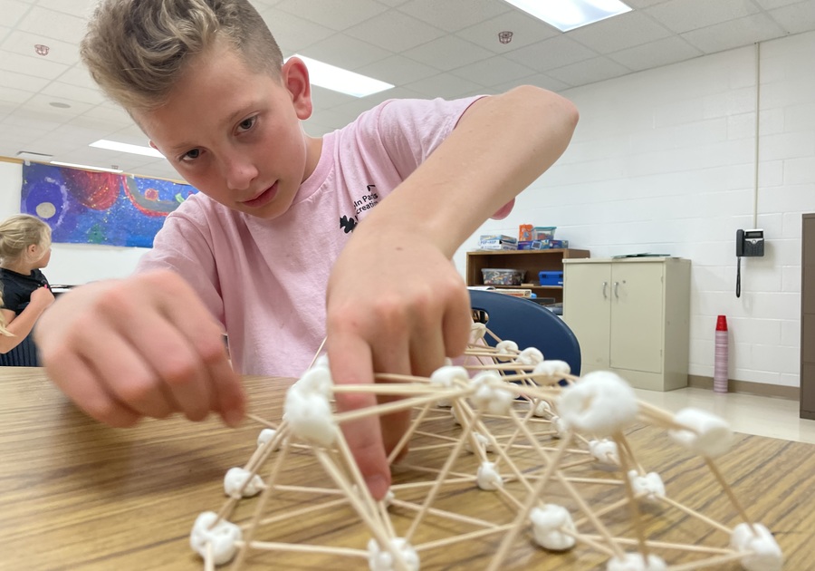 Child building with toothpicks and marshmallows