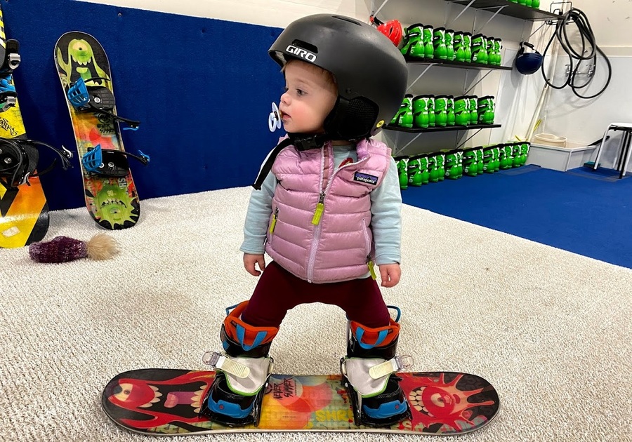 toddler on snowboard indoors