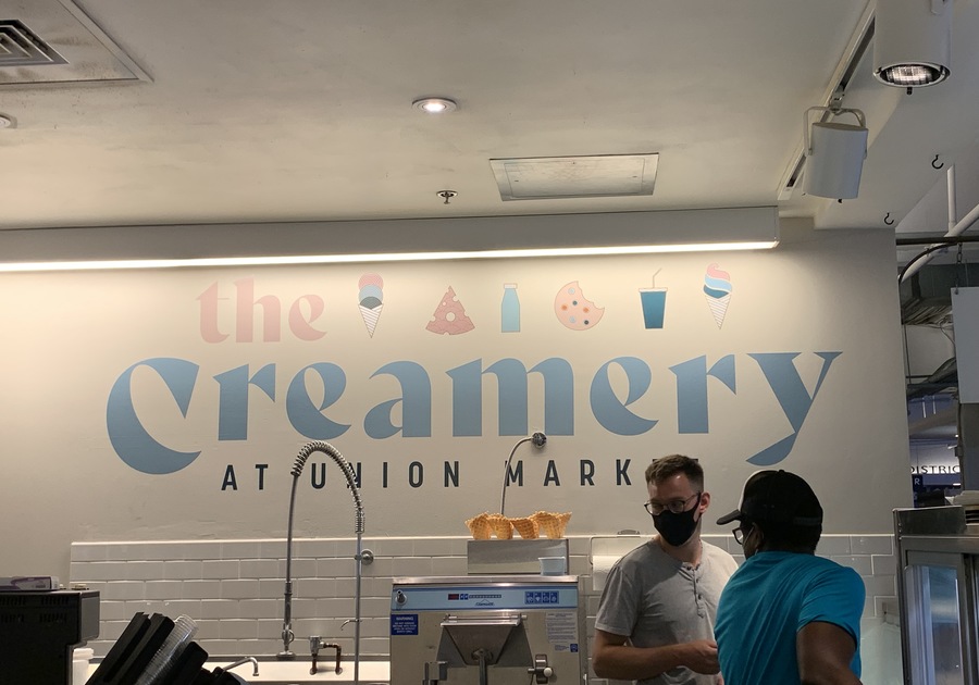 Two men stand in front of The Creamery at Union Market sign