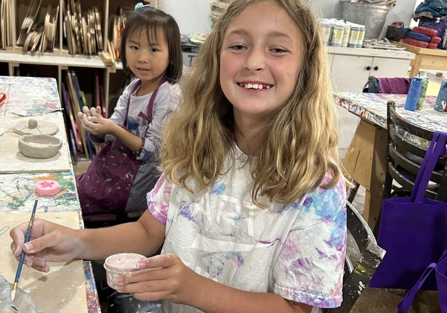 female campers smiling while painting