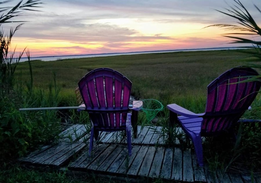 purple beach chairs facing chincoteague VA sunset and bay