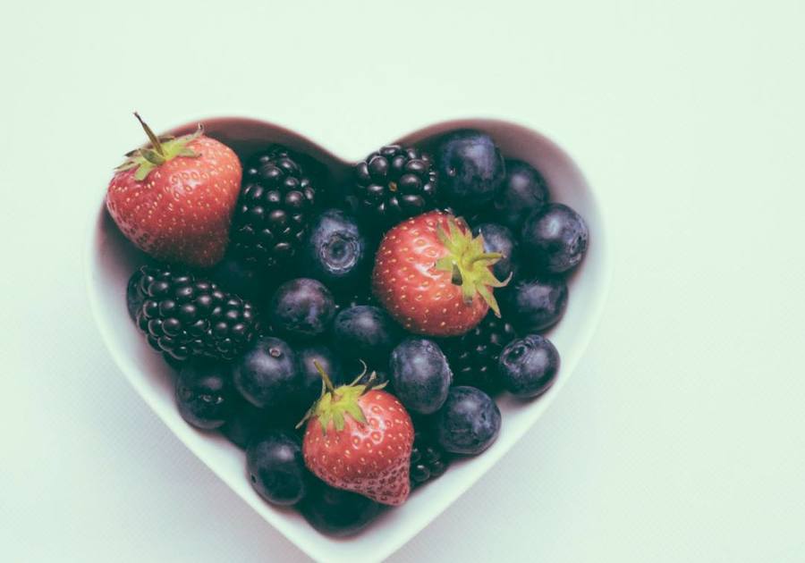 heart shaped bowl filled with blueberries, strawberries and blackberries
