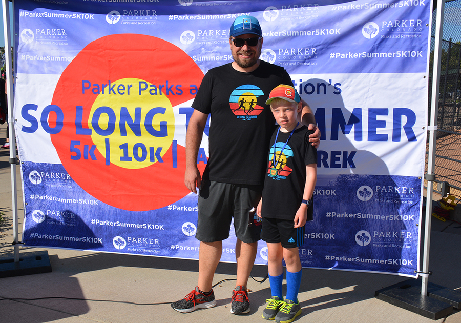 Parent and child at finish line of So Long to Summer 5K