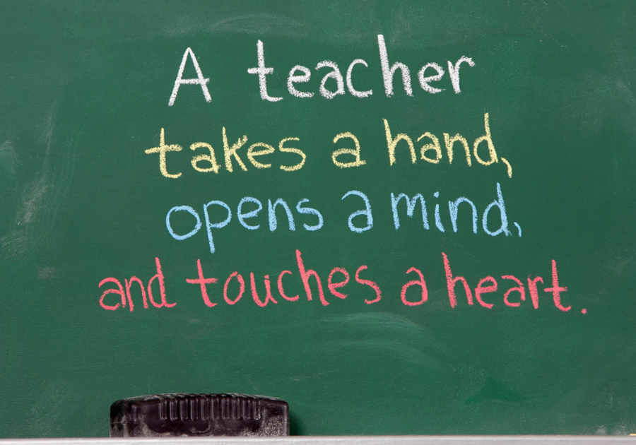 chalkboard with writing: A teacher takes a hand, opens a min, and touches a heart